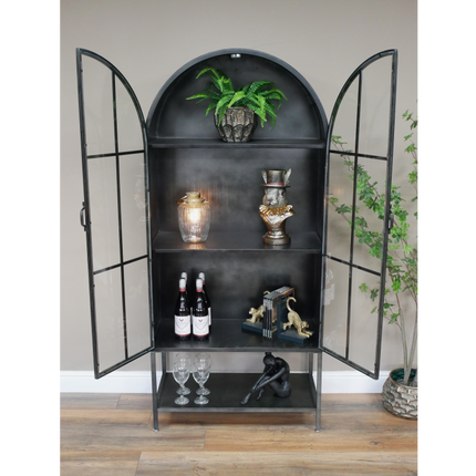 Arched tall slim glass fronted black metal storage display cabinet.