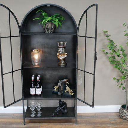 Arched tall slim glass fronted black metal storage display cabinet.